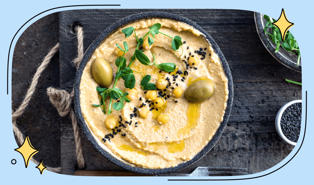 A bowl of hummus sprinkled with black sesame seeds