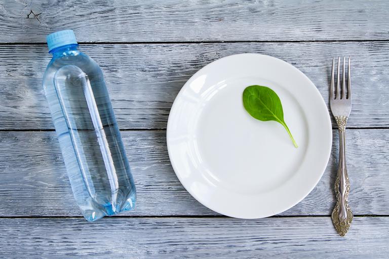 Empty plate and a bottle of water | Shutterstock