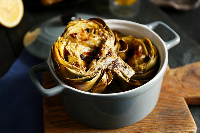 Grease the halves of the artichokes with olive oil. Add spices and send them to the oven. Bake artichokes for 10-15 minutes until they get browned. Then cover them with a sheet of foil and bake one more time for a few minutes to make the artichokes soft.